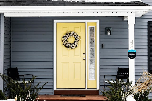 doorway to property featuring a shingled roof