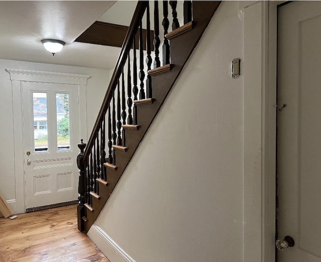 entryway with light wood-type flooring and stairs