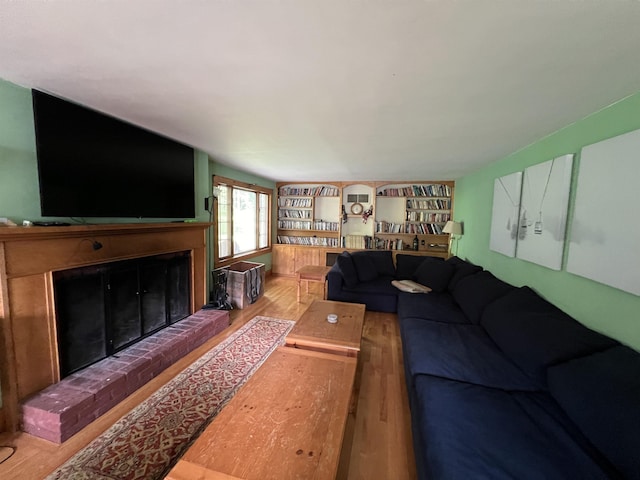 living area featuring a brick fireplace and wood finished floors