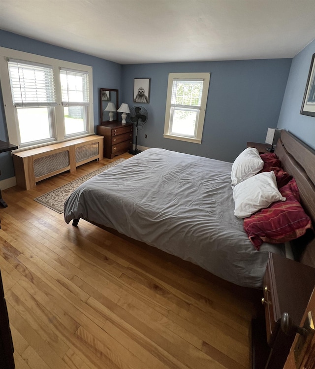 bedroom featuring radiator and hardwood / wood-style floors