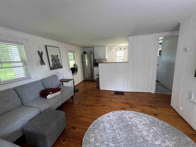 living room with dark wood-type flooring and visible vents