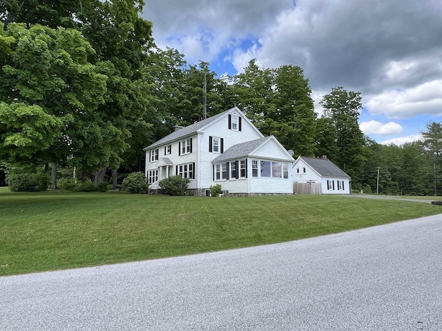 colonial house featuring a chimney and a front yard