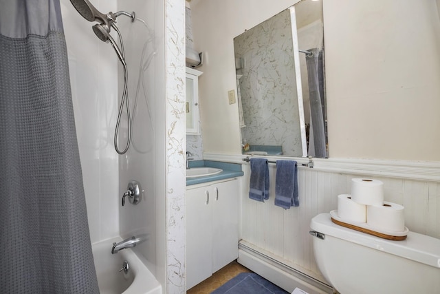 bathroom featuring toilet, a baseboard heating unit, a wainscoted wall, shower / tub combo, and vanity