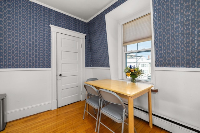 office space with light wood-style floors, wainscoting, crown molding, and wallpapered walls