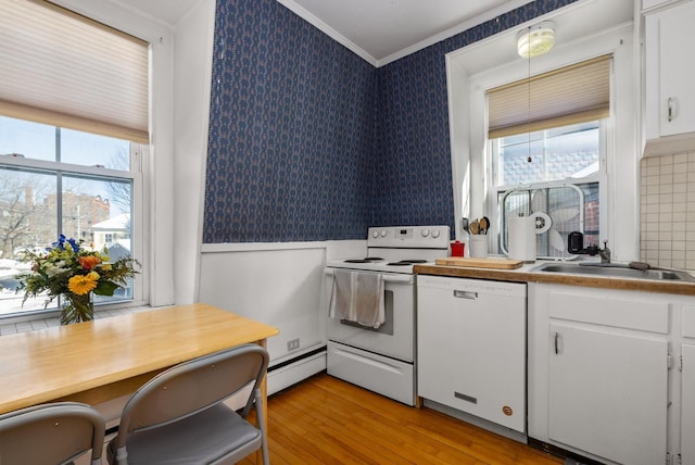 kitchen with ornamental molding, white cabinetry, a sink, white appliances, and wallpapered walls