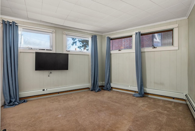 empty room with crown molding, a baseboard heating unit, baseboard heating, and carpet flooring