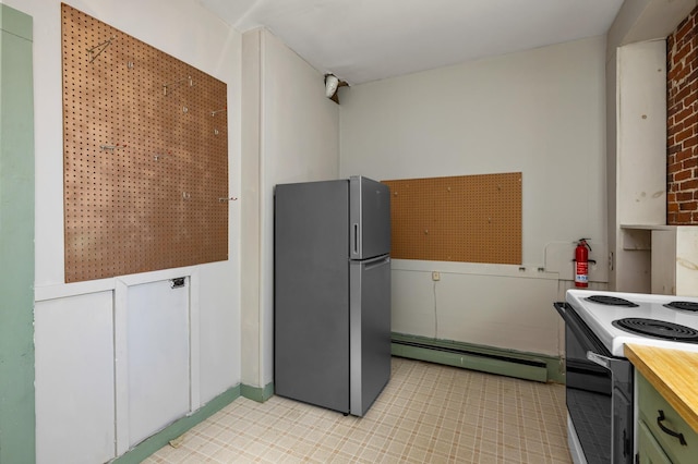 kitchen featuring freestanding refrigerator, butcher block counters, electric range, and baseboard heating