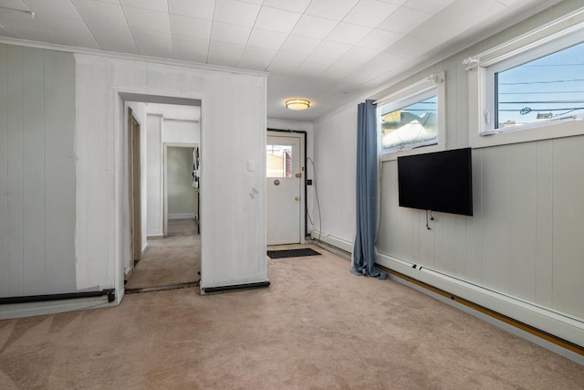 foyer featuring crown molding, baseboard heating, and light colored carpet