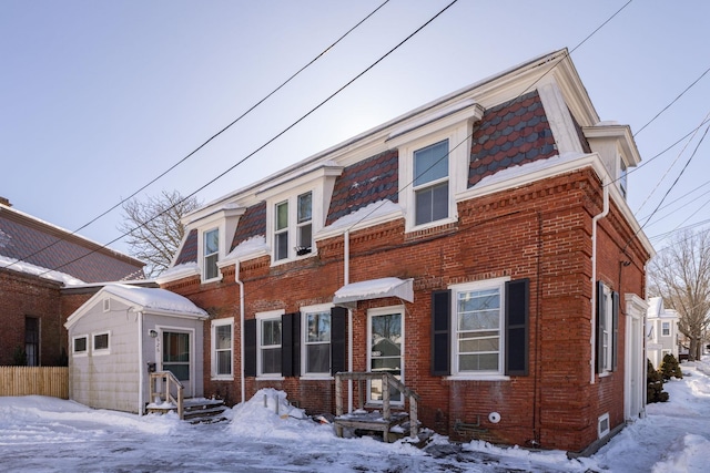 view of front facade featuring brick siding and mansard roof