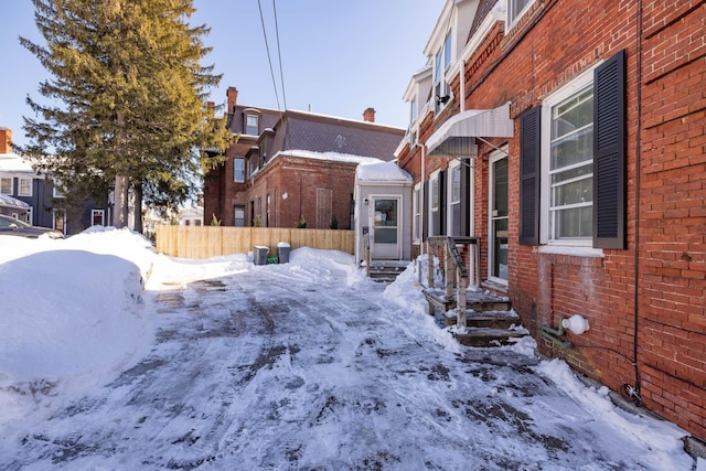 snowy yard with entry steps and fence