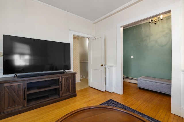 living room featuring a chandelier, baseboard heating, wood-type flooring, and crown molding