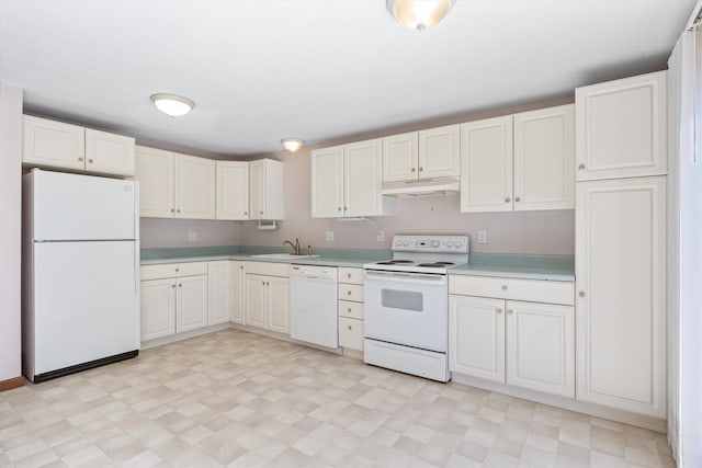 kitchen with under cabinet range hood, white appliances, a sink, light countertops, and light floors