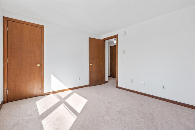 interior space featuring light carpet and baseboards