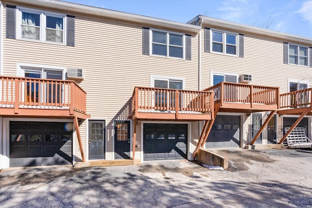 multi unit property with an attached garage and a wall mounted AC