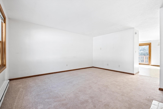 carpeted spare room featuring baseboards and baseboard heating