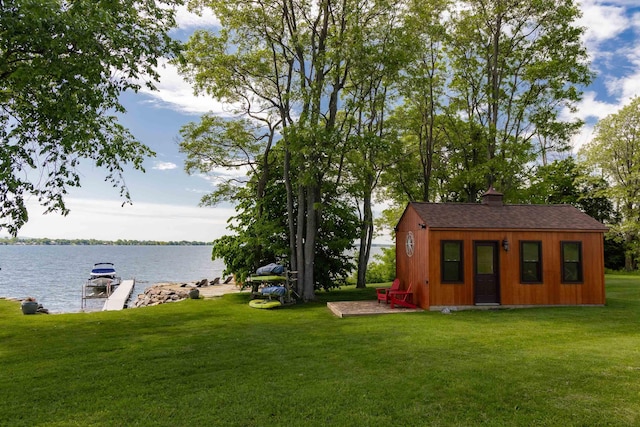 view of yard featuring a boat dock, a water view, and an outdoor structure