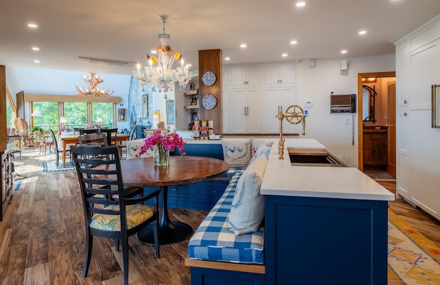 dining space with a chandelier, wood finished floors, and recessed lighting