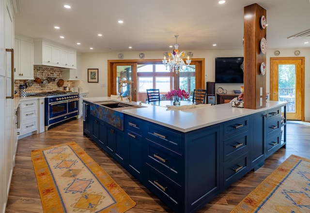 kitchen with dark wood finished floors, light countertops, white cabinets, blue cabinets, and double oven range