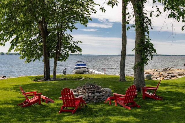 view of yard with an outdoor fire pit and a water view