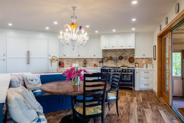 dining area with a notable chandelier, breakfast area, dark wood finished floors, and recessed lighting