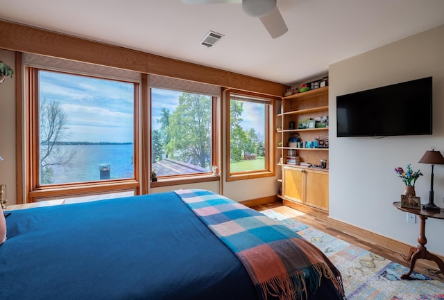 bedroom featuring light wood-type flooring, ceiling fan, and visible vents