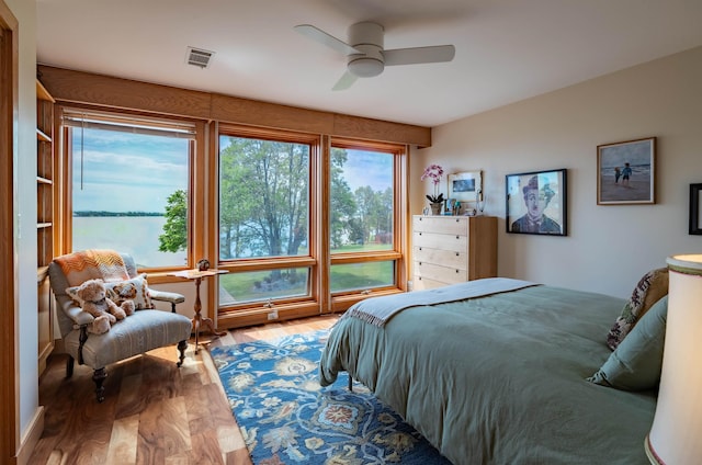 bedroom featuring wood finished floors, visible vents, and a ceiling fan