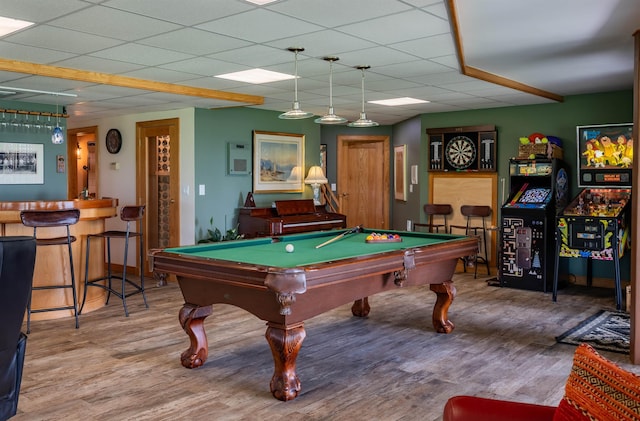 rec room with pool table, a bar, wood finished floors, and a paneled ceiling