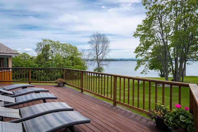 wooden deck featuring a water view and a lawn