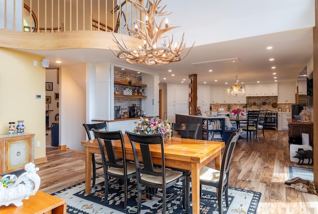 dining room with light wood-style floors, recessed lighting, and a notable chandelier