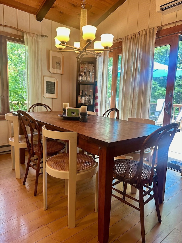 dining area featuring light wood finished floors, a wall mounted AC, wood ceiling, a chandelier, and beamed ceiling