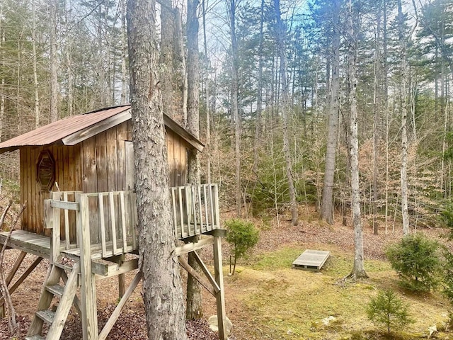 view of yard with an outdoor structure and a forest view