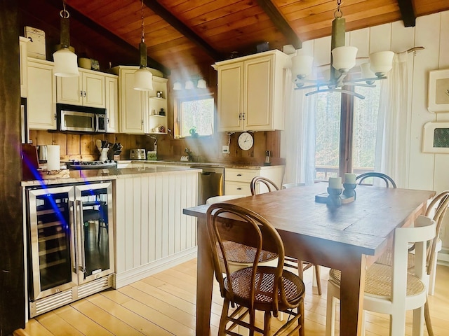 kitchen featuring lofted ceiling with beams, wood ceiling, wine cooler, appliances with stainless steel finishes, and decorative light fixtures