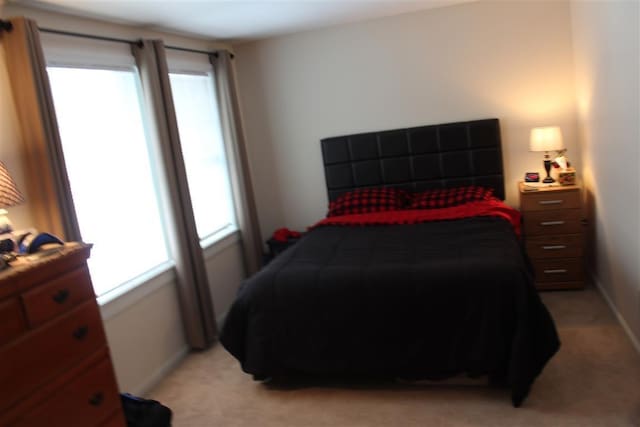 bedroom featuring light carpet and baseboards