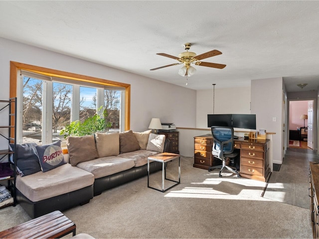 carpeted living room with a textured ceiling and a ceiling fan