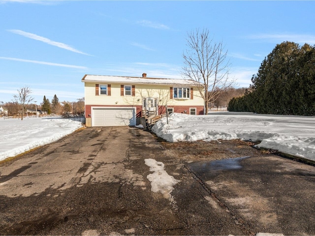 raised ranch featuring driveway and an attached garage