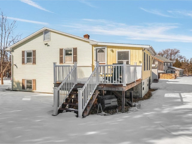 rear view of house with a chimney, stairway, and a wooden deck