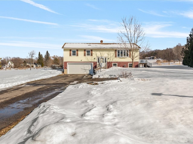 raised ranch with driveway and an attached garage