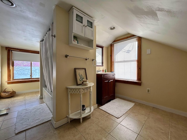 additional living space with vaulted ceiling, plenty of natural light, and baseboards