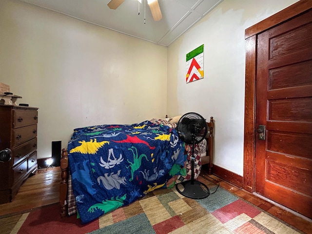 bedroom featuring ceiling fan, baseboards, and wood finished floors