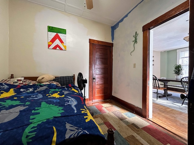 bedroom with baseboards, a ceiling fan, and wood finished floors