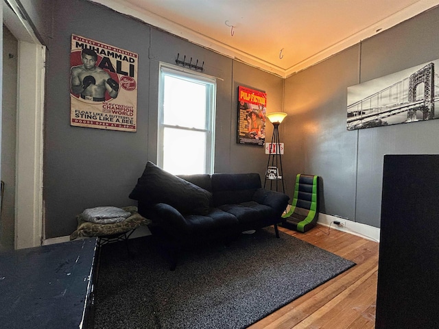 living room with crown molding, baseboards, and wood finished floors