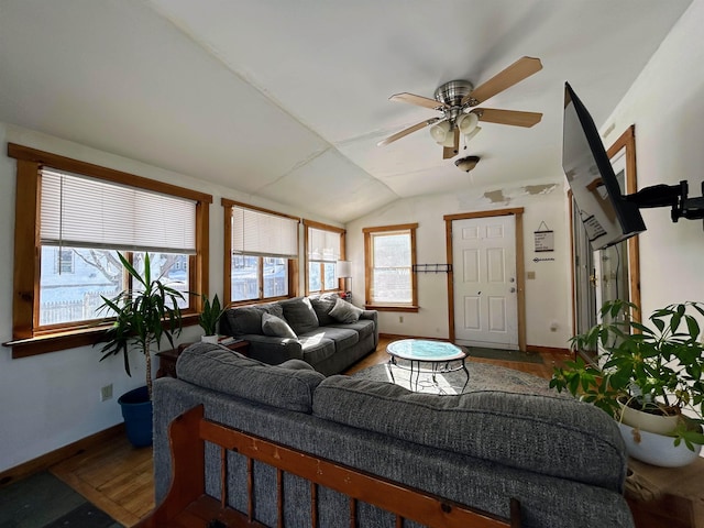 living area with lofted ceiling, ceiling fan, wood finished floors, and baseboards