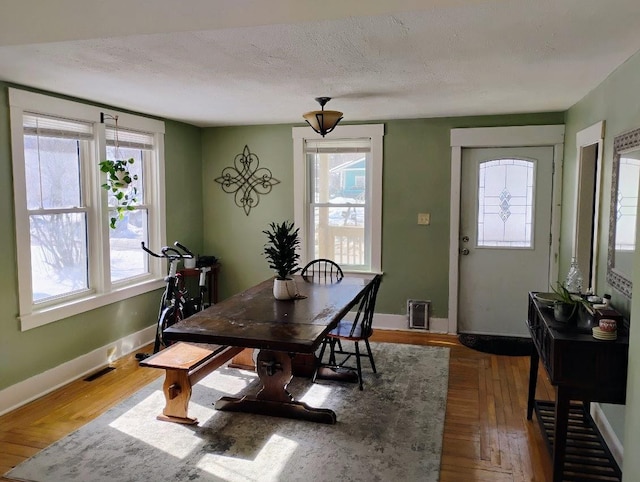 dining room featuring a wealth of natural light, visible vents, a textured ceiling, and baseboards