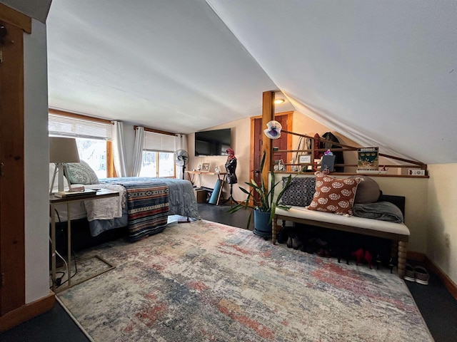 bedroom featuring lofted ceiling and baseboards