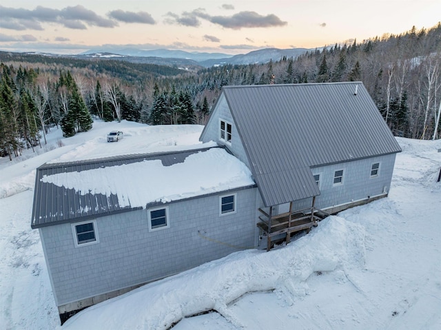 snowy aerial view featuring a forest view