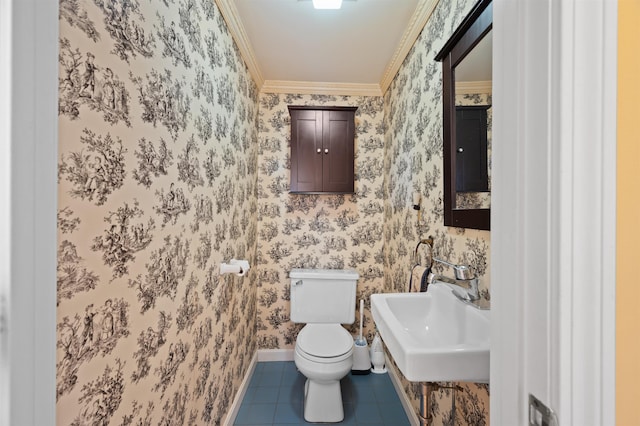 bathroom with toilet, a sink, tile patterned floors, wallpapered walls, and crown molding