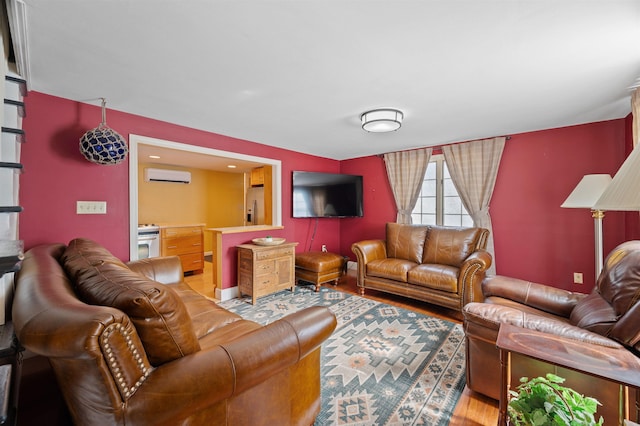 living room featuring light wood-style floors and an AC wall unit