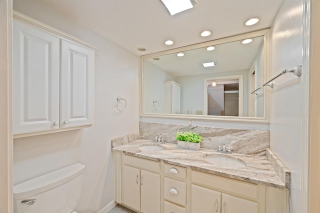 full bathroom with recessed lighting, a sink, toilet, and double vanity