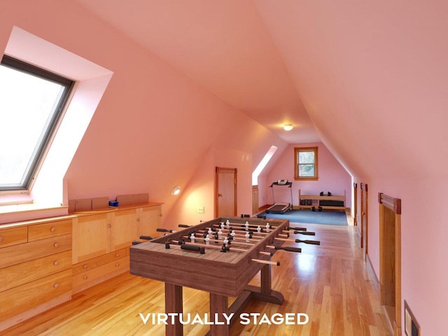 rec room with visible vents, vaulted ceiling, and light wood-style flooring