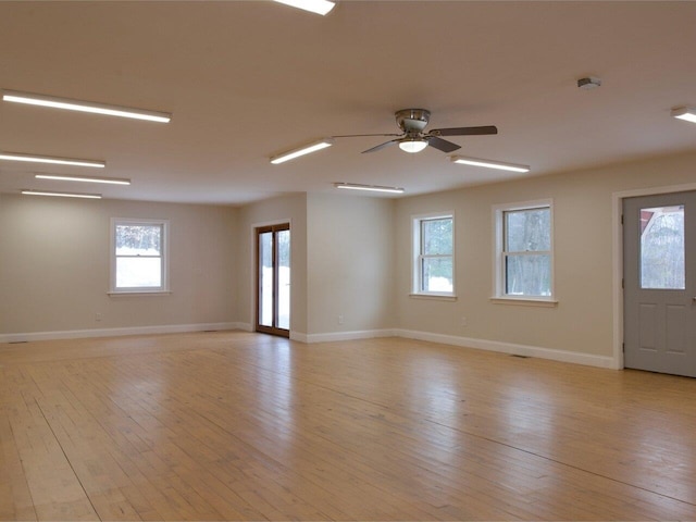 spare room with ceiling fan, light wood-type flooring, and baseboards